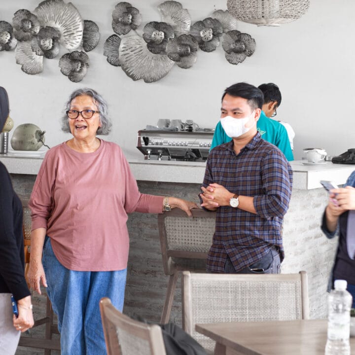 Foto staf Maluk Stay yang ramah sedang berbincang dengan tamu di area restoran hotel